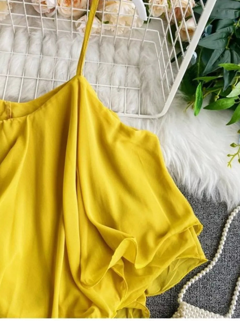 Yellow ruffled camisole with spaghetti straps and delicate ruffles.