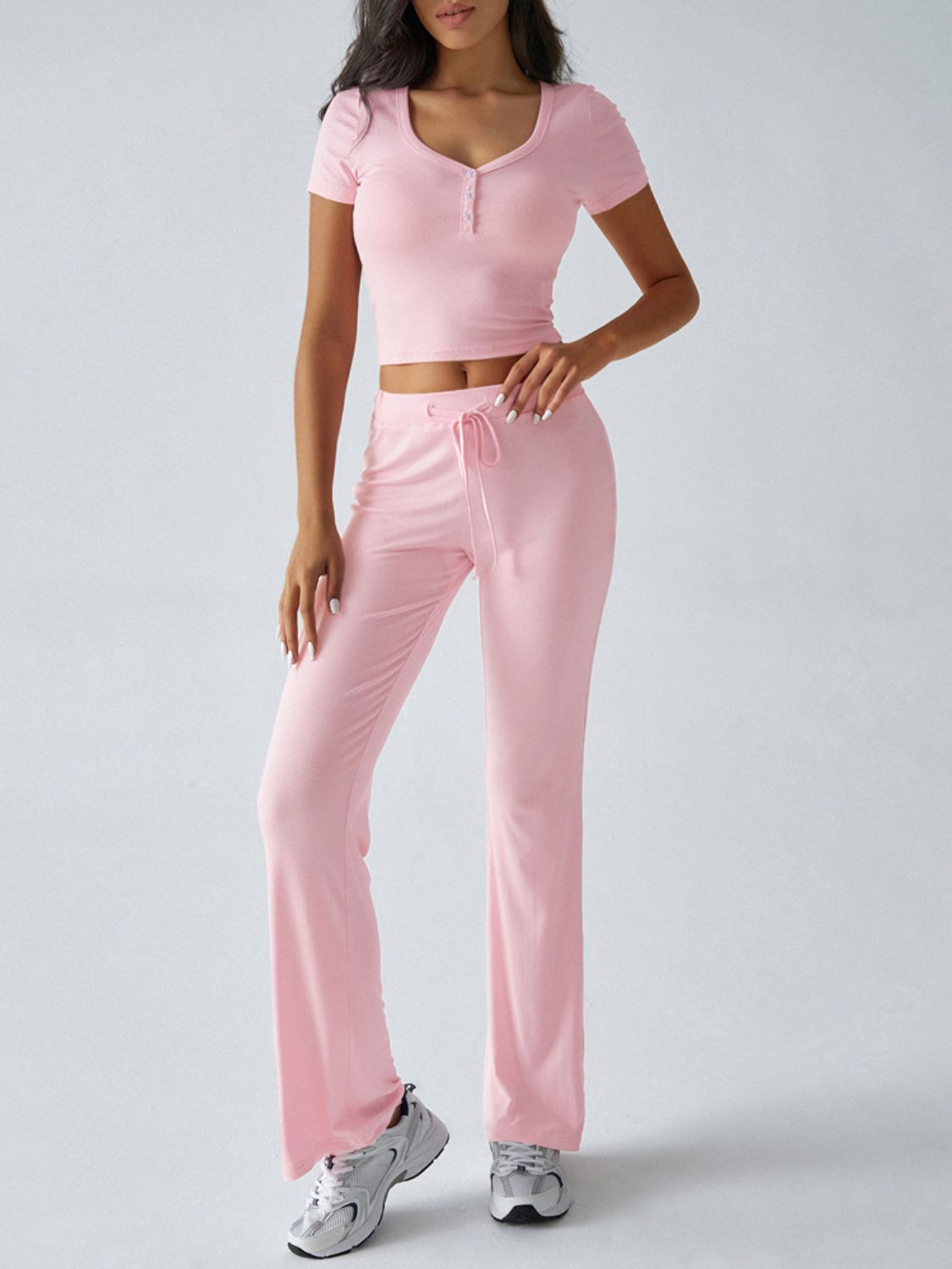 Blush pink button-front crop top and flared lounge pants with drawstring waist.