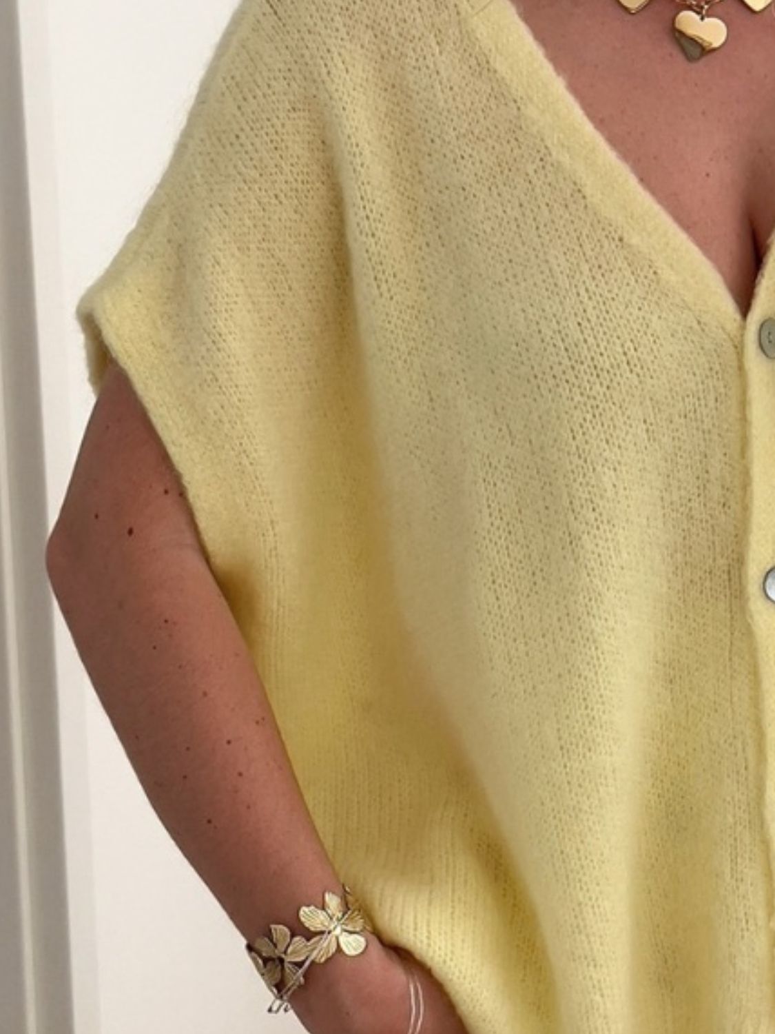 Cap sleeve mohair cardigan in pastel yellow with V-neck and button front.