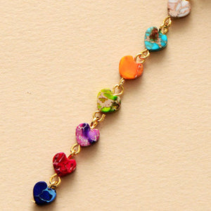 Rainbow heart cascade necklace with gold chain and multicolor stone hearts.