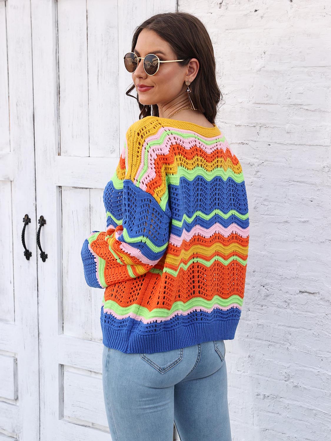 Crochet sweater with rainbow chevron stripes in yellow, pink, green, orange, and blue, featuring an open knit design.
