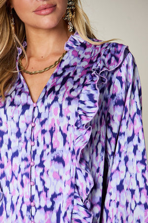 Blue purple blouse with abstract print, ruffle front, and button detail.