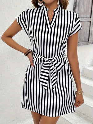 Chic black and white striped mini dress with V-neck, cap sleeves, and self-tie waist.