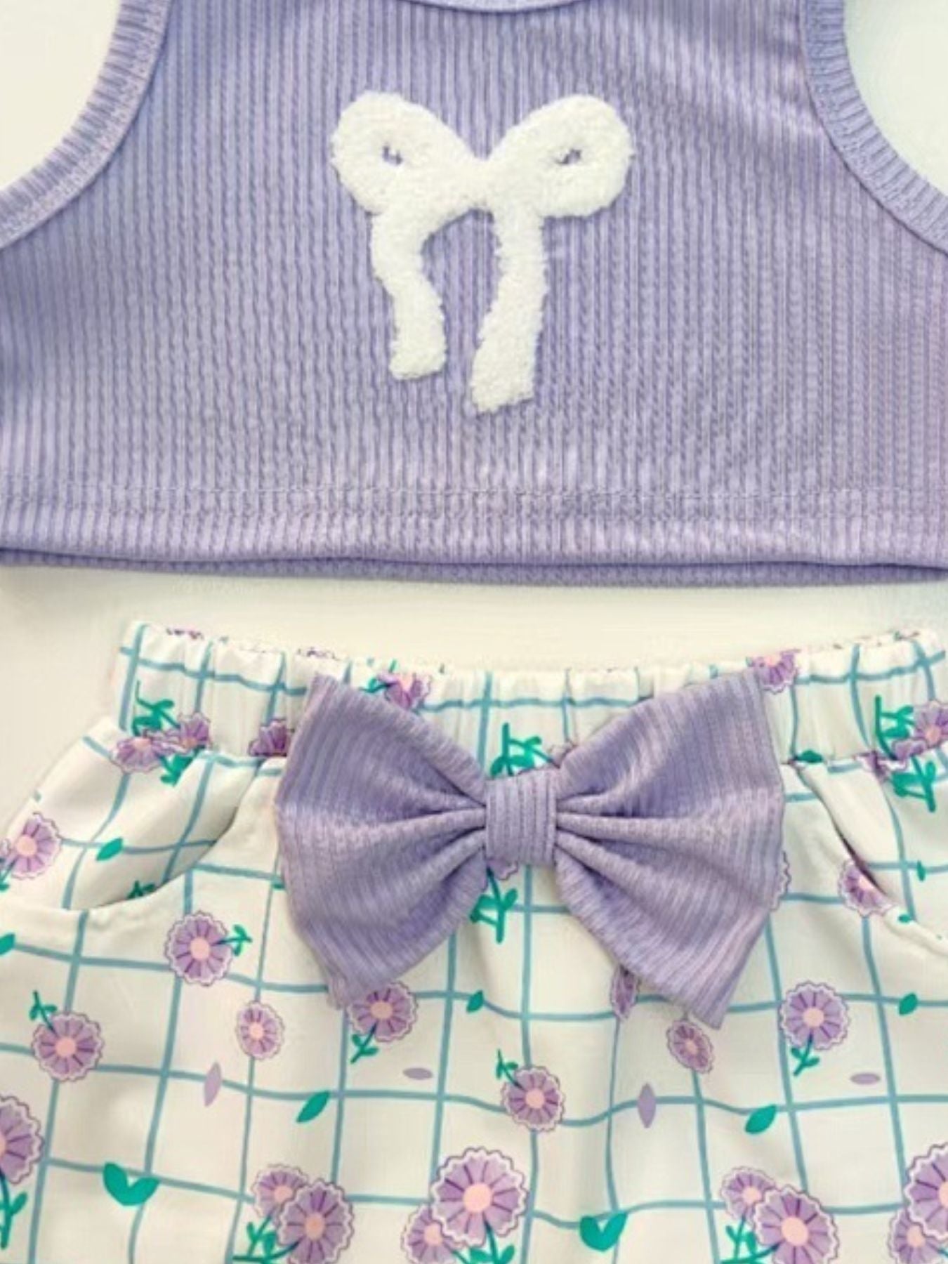 Lavender ribbed tank top with white bow detail and floral grid print shorts with lavender bow