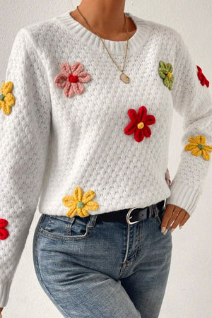 White knit sweater with colorful crochet floral embellishments and a textured pattern.