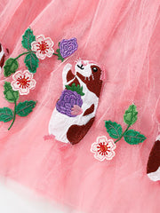 Pink tulle toddler dress with embroidered guinea pig and floral details.
