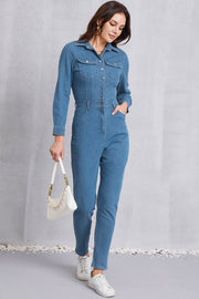 Denim utility jumpsuit in medium wash with defined waist, button front, and chest pockets.