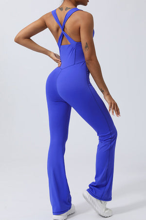 Blue cross-back flare leg unitard with a twisted strap detail and athletic fit.