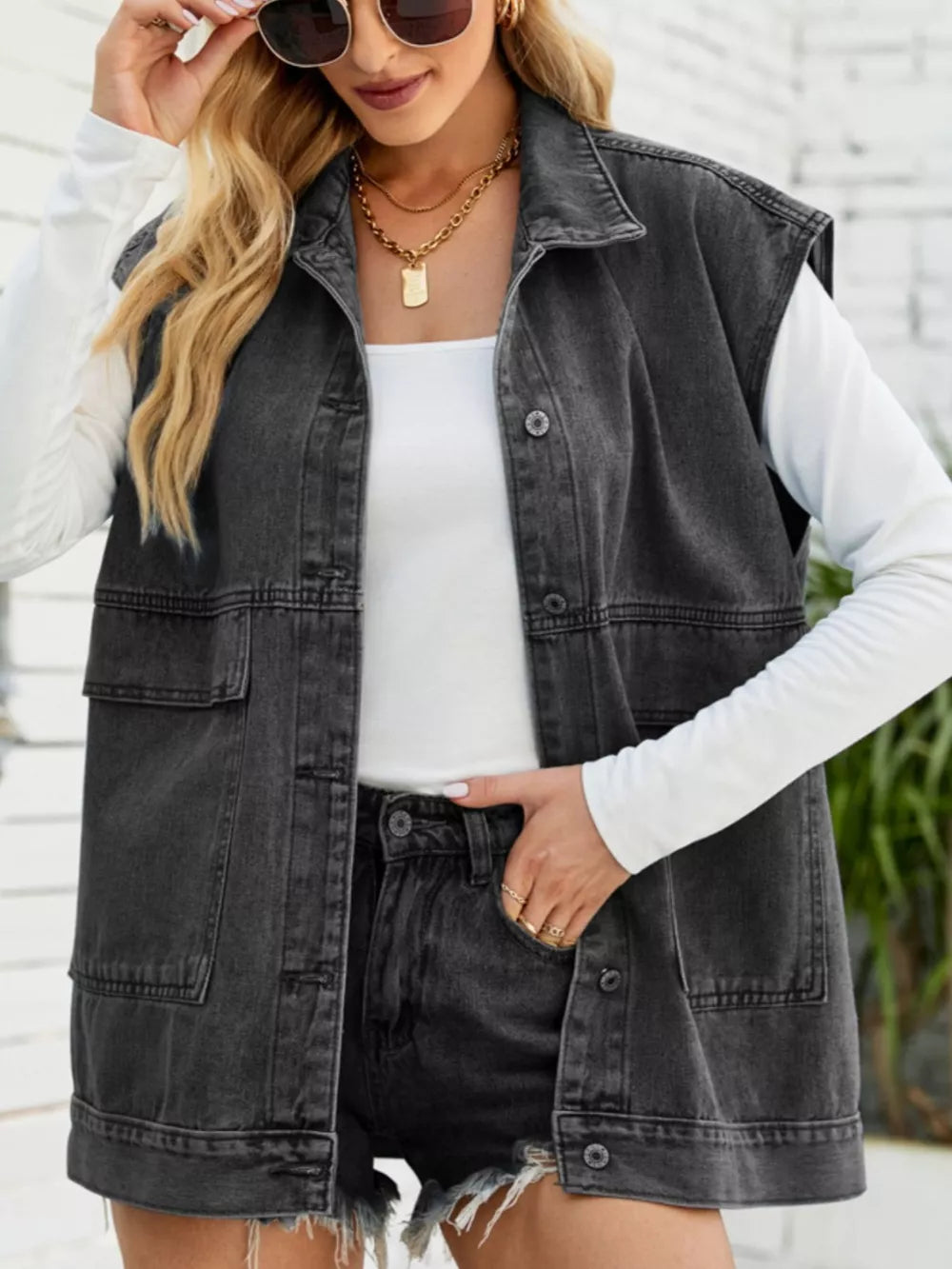 Relaxed-fit sleeveless dark gray denim vest with button-down front and chest pockets.