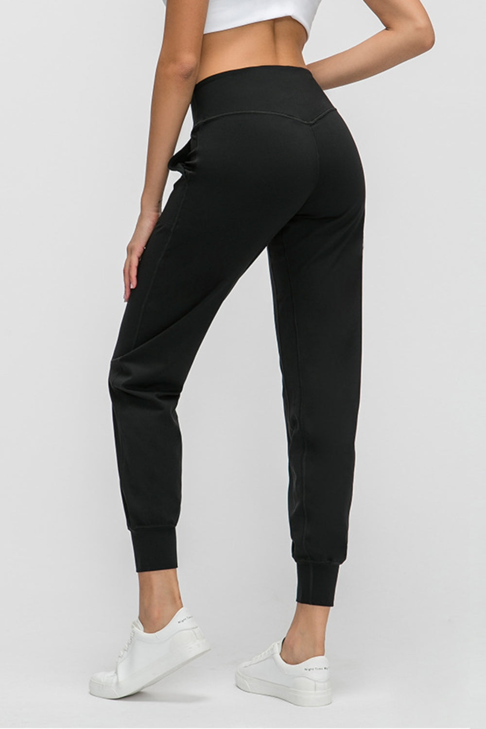 Black jogger fit performance trousers with pockets and cuffed ankles.