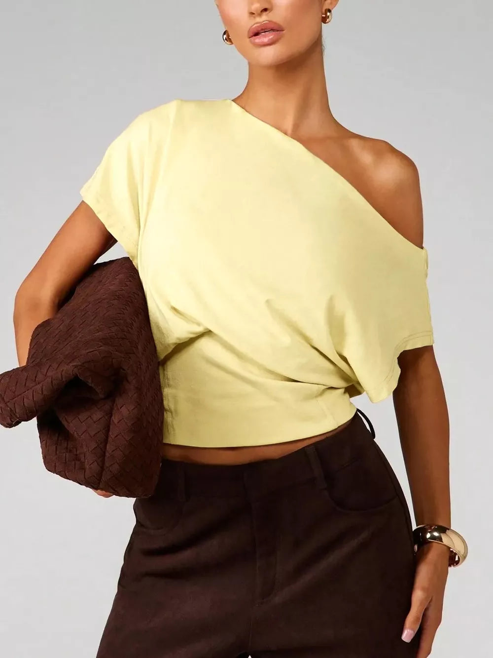 Yellow asymmetrical crop t-shirt with draped fit and short sleeves.