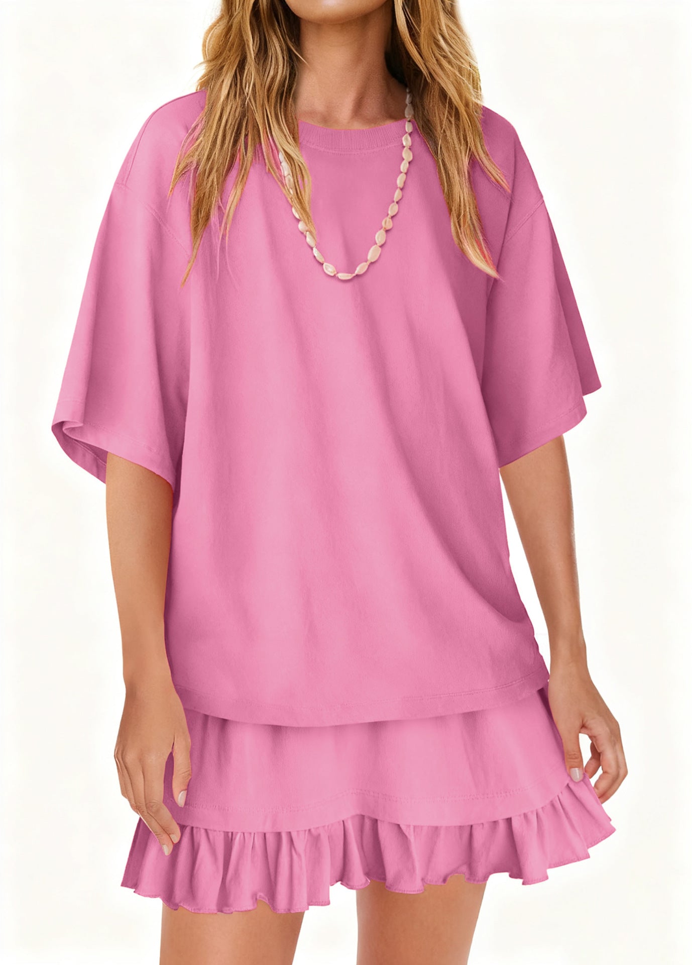 Light pink ruffled tee and skirt set with relaxed fit and short sleeves.