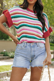 Textured knit sweater with colorful stripes and contrast red trim on sleeves and neckline.
