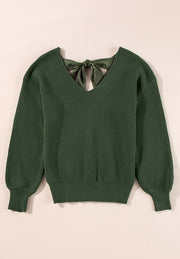 Dark green ribbed knit sweater with a V-neck and satin bow detail at the back.