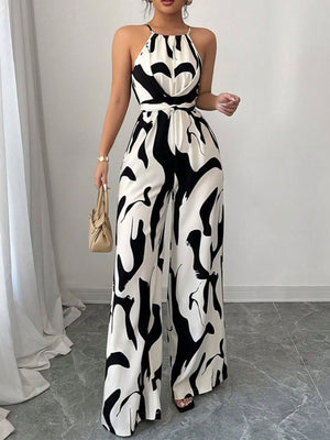 Chic abstract print halter jumpsuit in black and white, featuring wide legs and a tie waist.