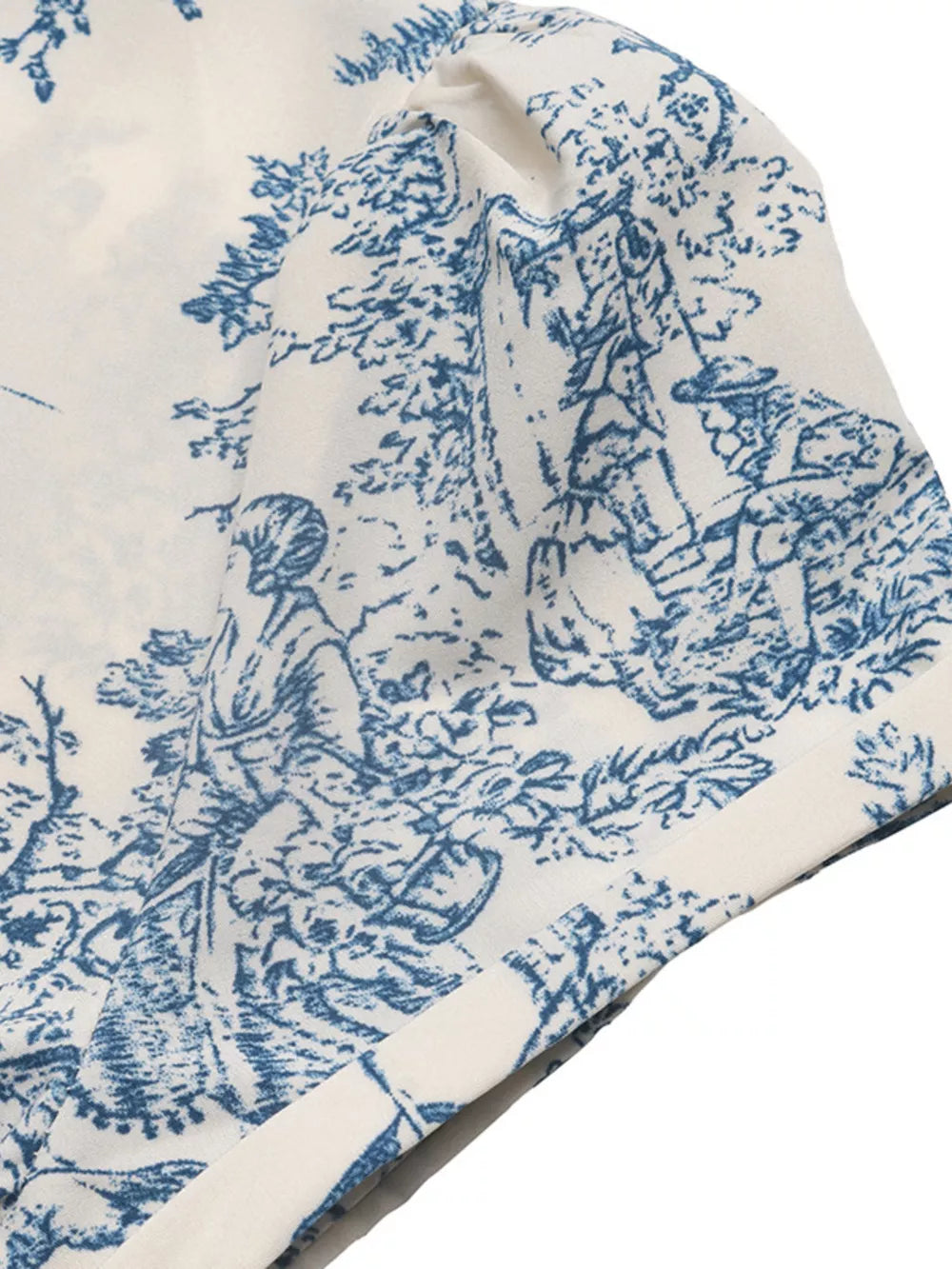 Toile print midi dress with blue and white scenic pattern and V-neck detail.