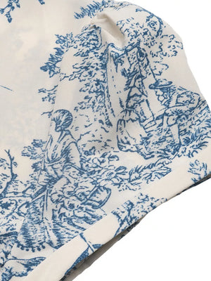 Toile print midi dress with blue and white scenic pattern and V-neck detail.
