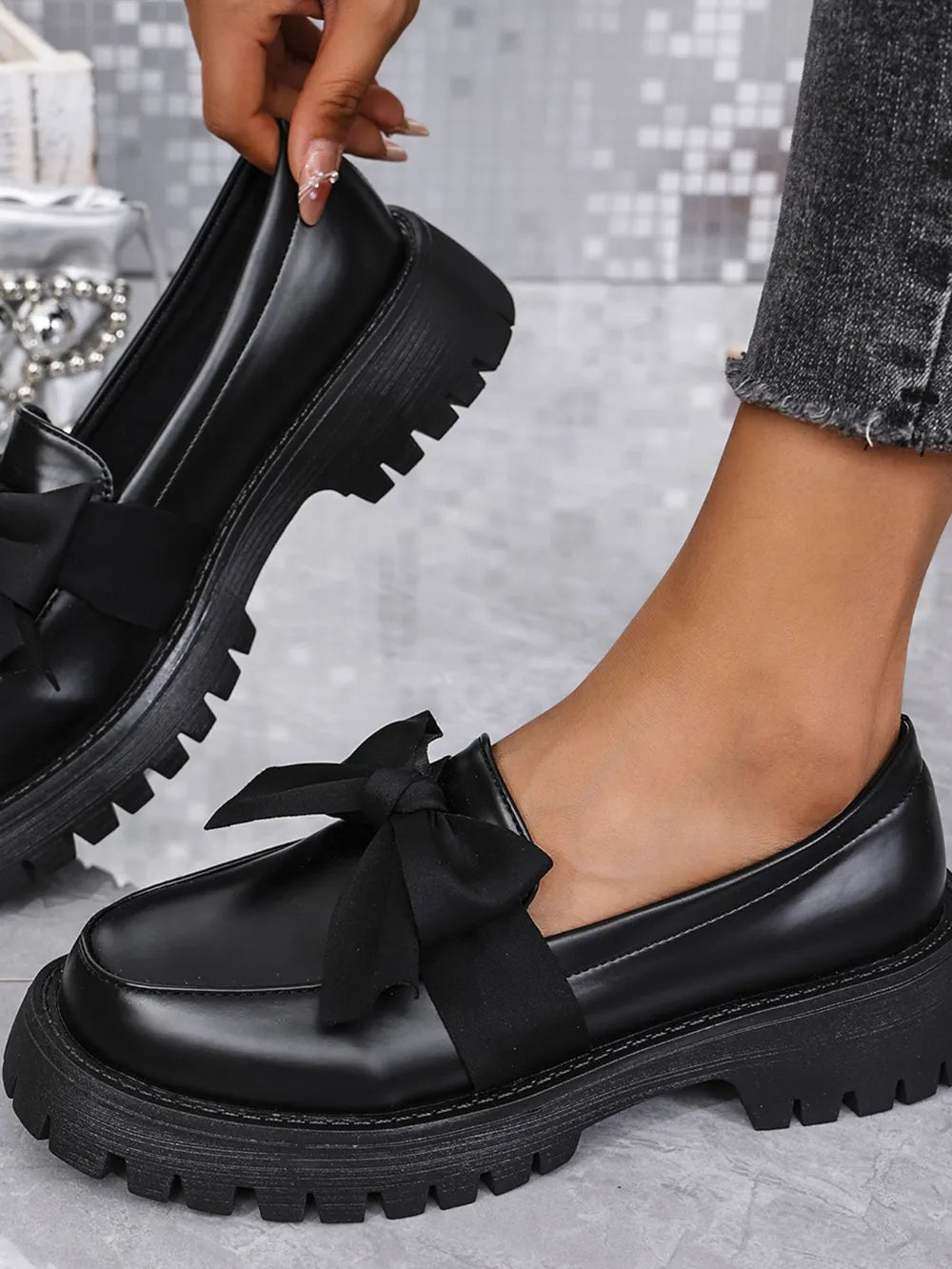 Black matte platform bow loafers with a chunky lug sole.