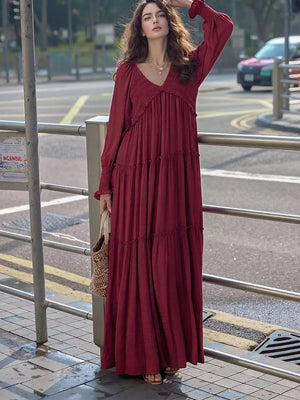 Wine red smocked V-neck tiered maxi dress with long sleeves.