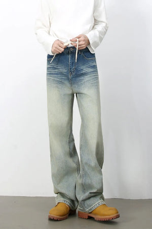 Faded wash wide-leg jeans with drawstring waist and distressed details.