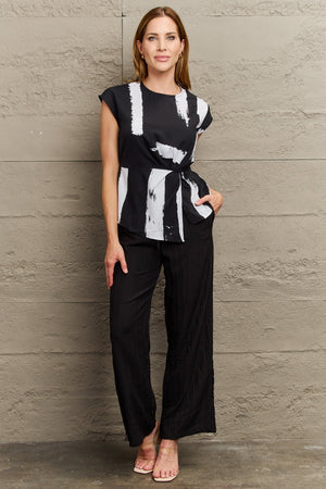 Black and white brushstroke print tie-waist blouse with cap sleeves.
