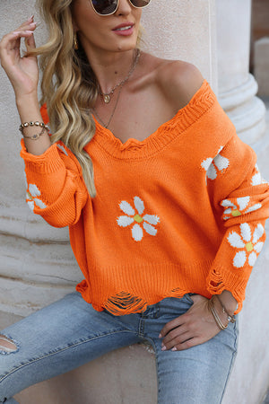 Orange acrylic sweater with daisy appliqué and distressed edges.