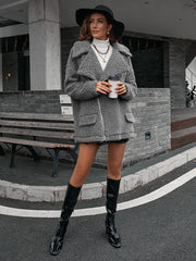 Gray teddy moto jacket with asymmetrical zip and collared neckline.