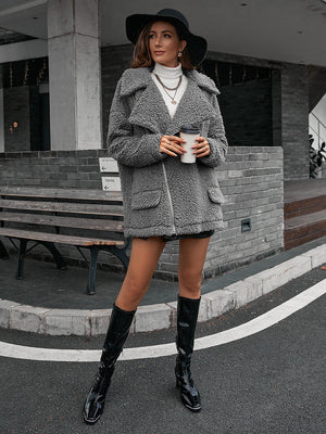 Gray teddy moto jacket with asymmetrical zip and collared neckline.