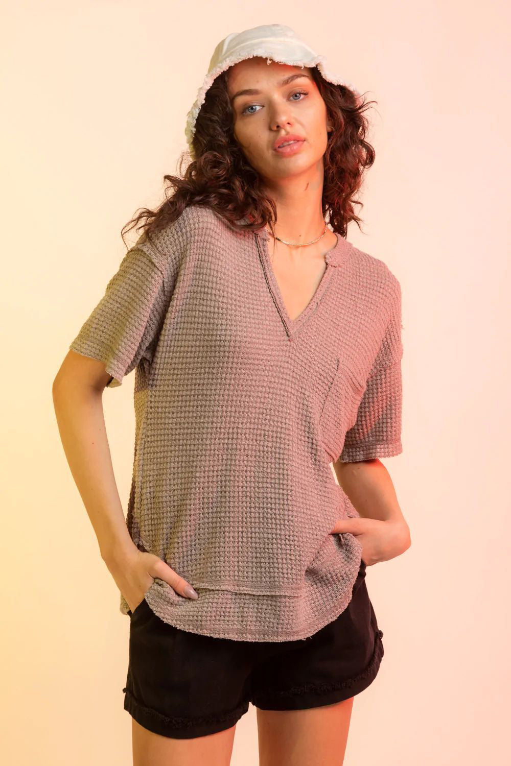 Taupe waffle knit v-neck top with short sleeves and a chest pocket.