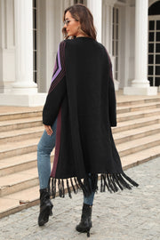 Black cardigan with geometric trim on sleeves and fringed hemline, styled with jeans.