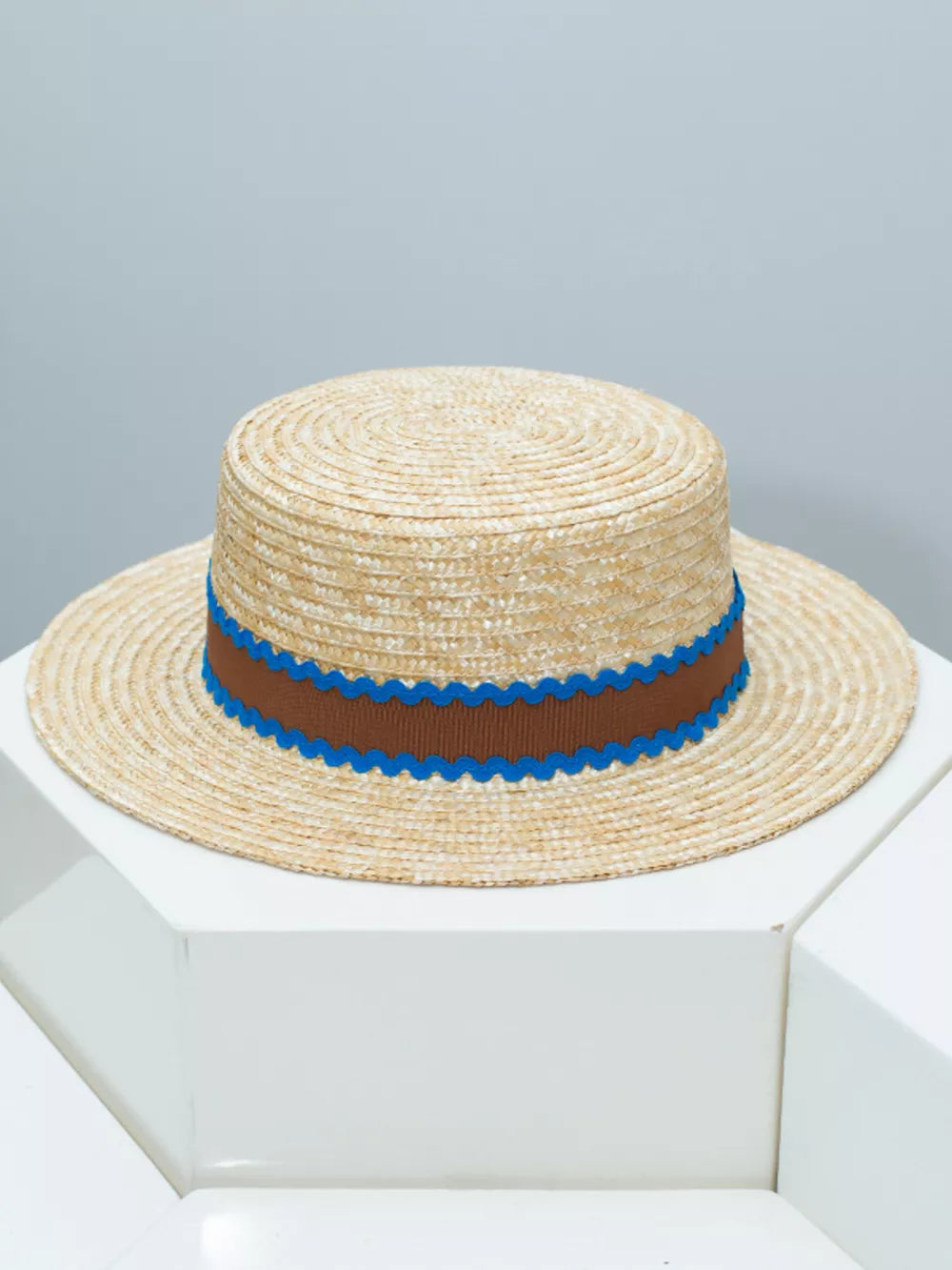 Straw boater hat with brown band and blue scalloped trim