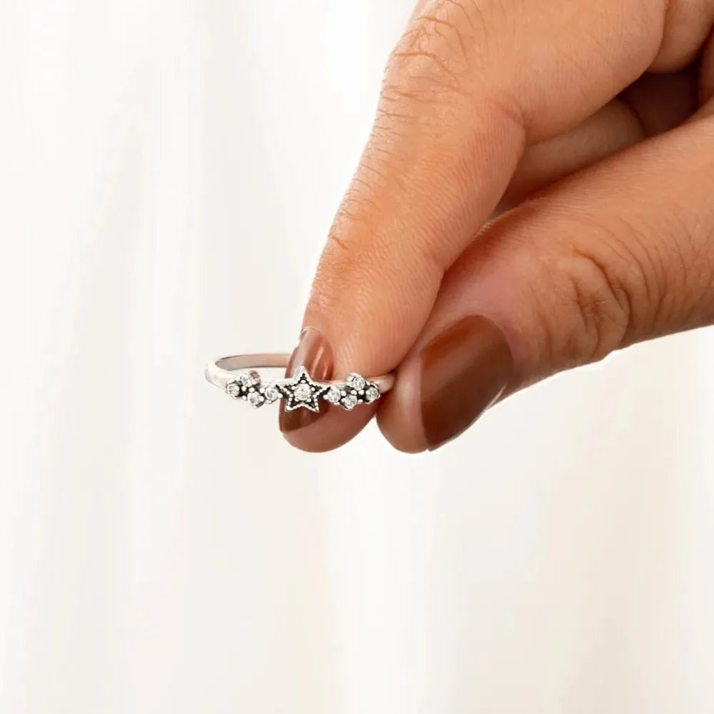 Silver band ring with a celestial cluster of stars and small stones
