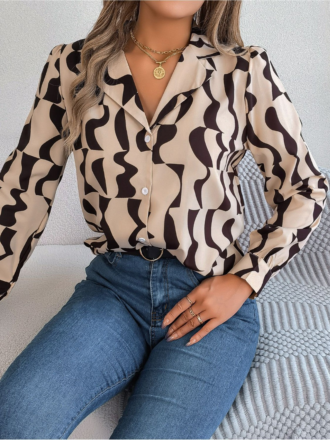 Tan abstract wave print silk-touch blouse with button front and spread collar.