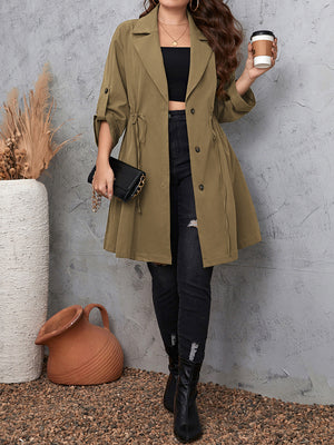Olive green trench coat with gathered waistline and roll-up sleeves.