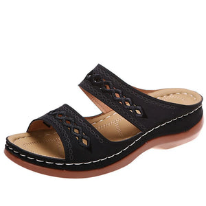 Black embroidered strap comfort slides with a cushioned footbed and wedge heel.