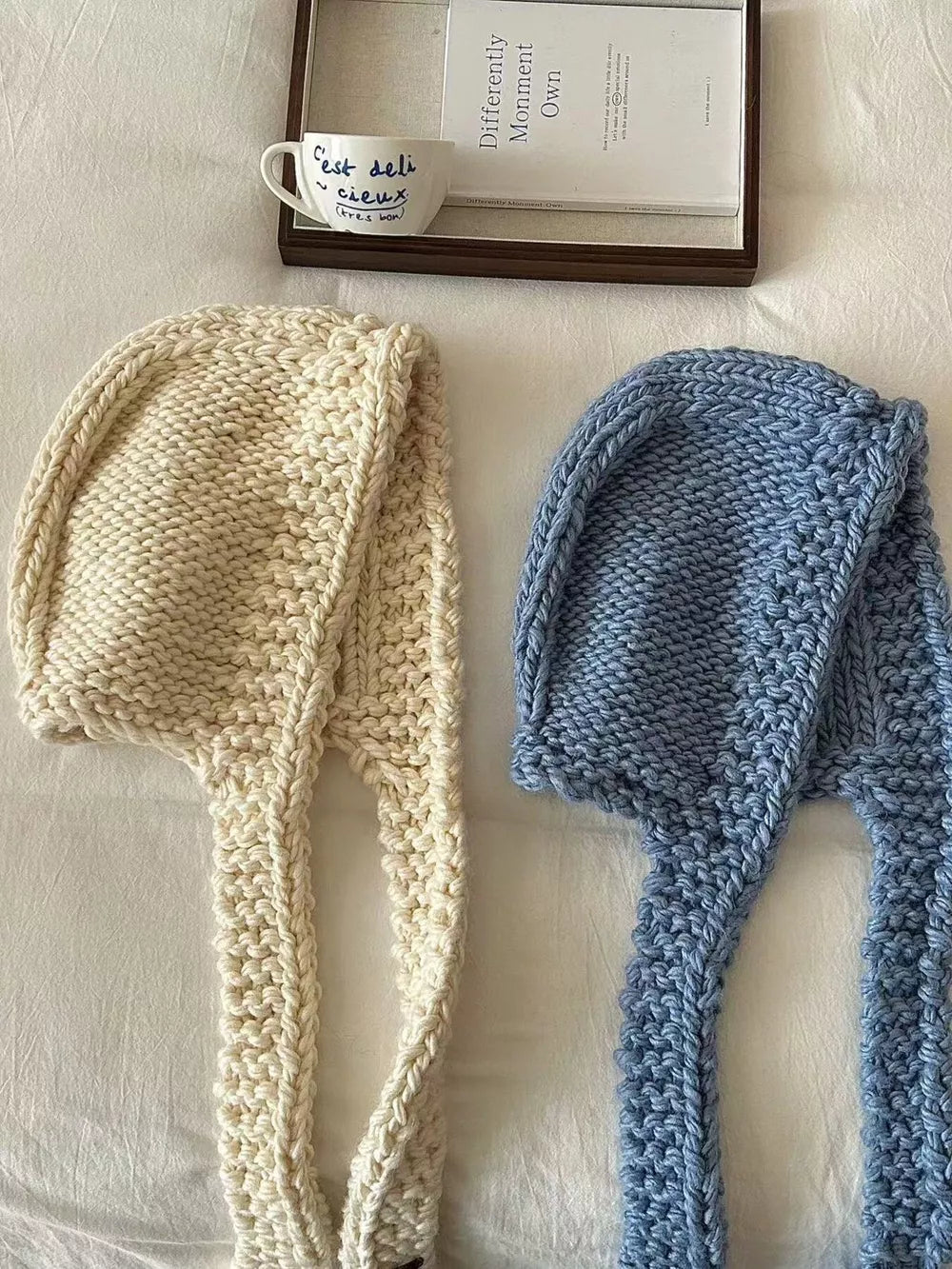 Cozy wool earflap beanie hat in off-white and blue, chunky knit with long ear flaps.