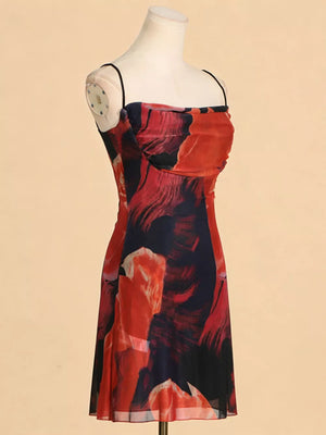 Red and blue abstract print spaghetti strap dress with a ruched bodice.