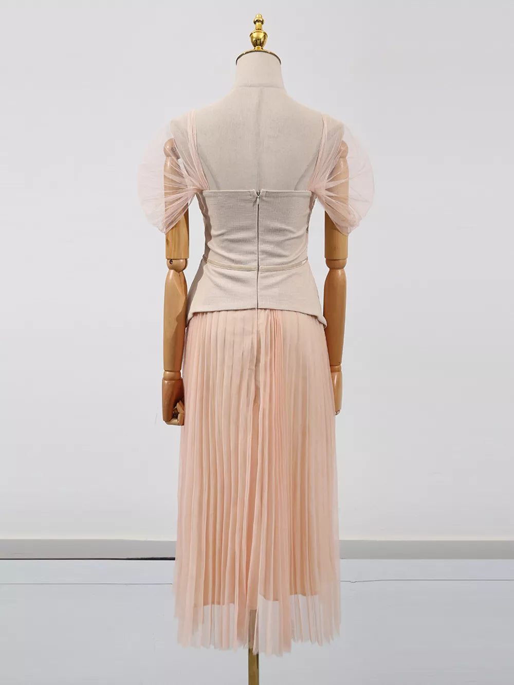 Embroidered tulle midi dress with sheer puff sleeves and a pleated skirt in a soft pink hue.