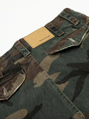 Men's distressed camouflage cargo pants with a tan leather patch and pocket details.