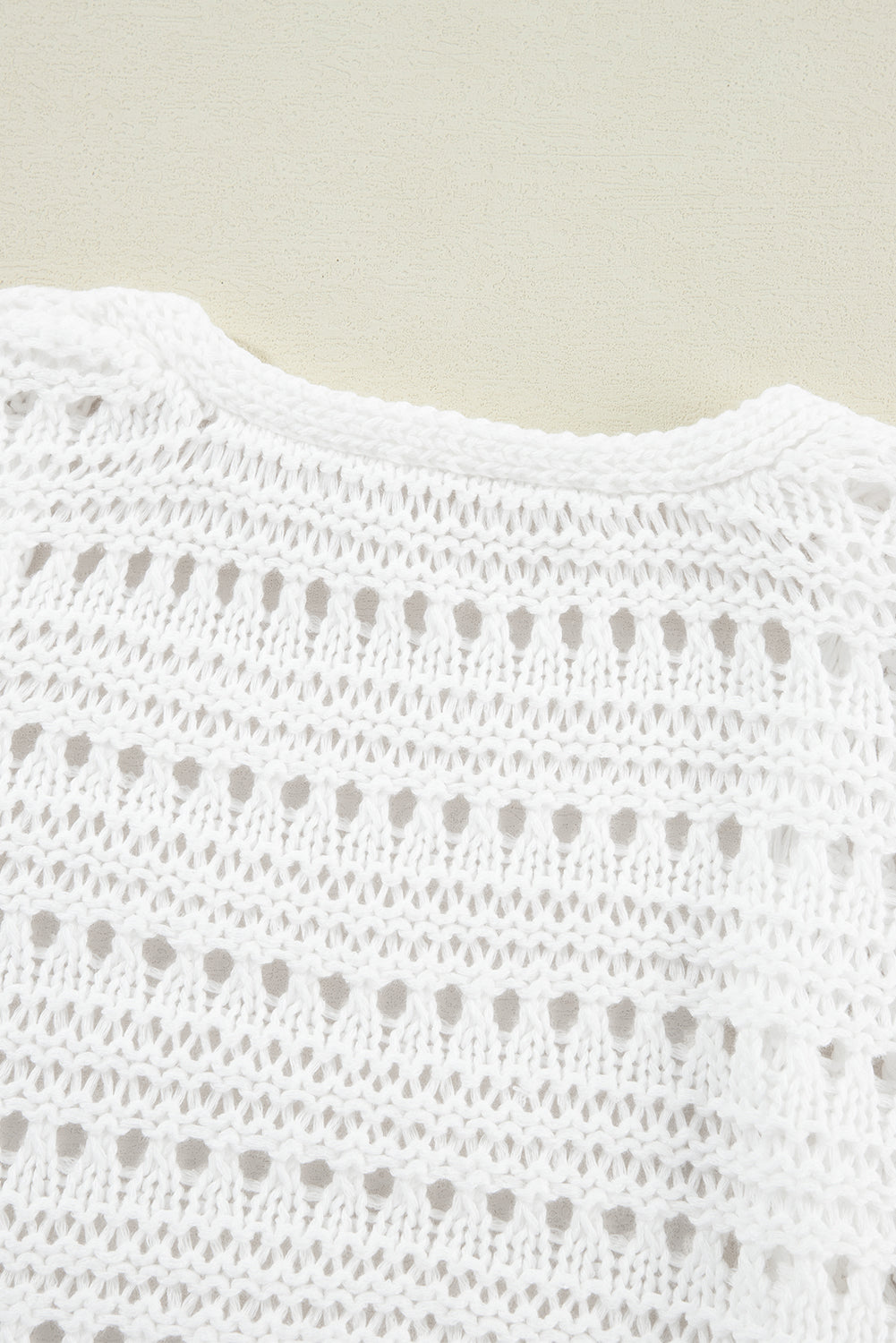 White open-knit dolman sleeve cardigan with a round neckline and breathable acrylic fabric.