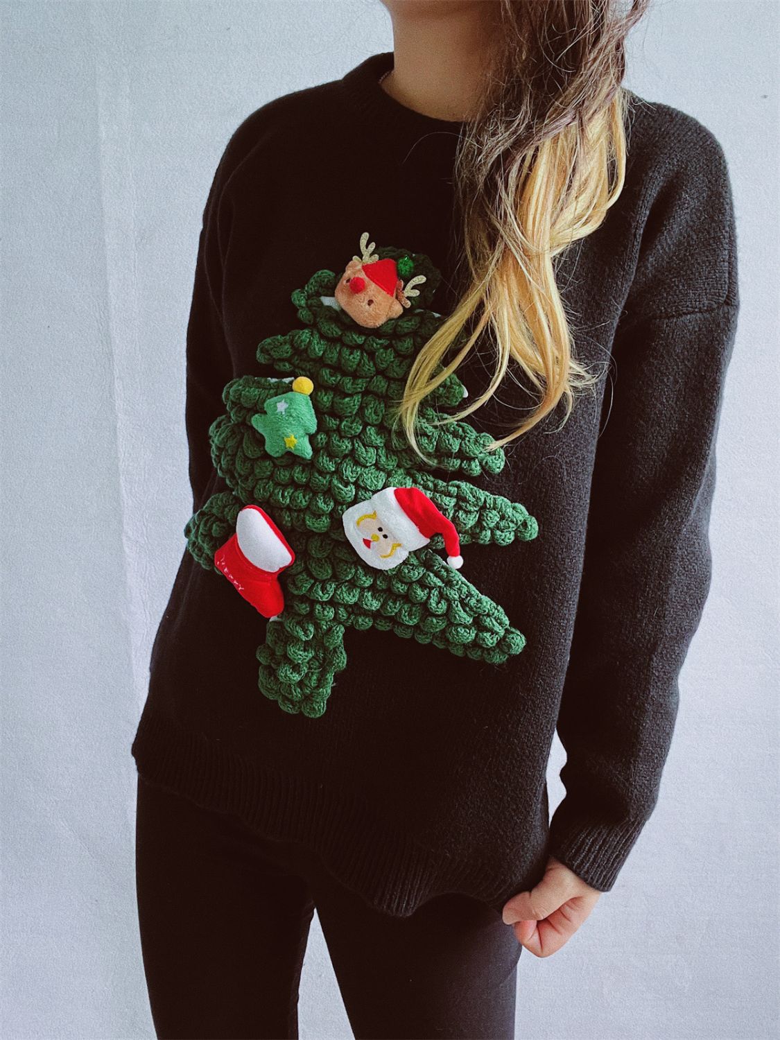 Black acrylic knit sweater with a 3D embellished Christmas tree featuring Santa, elf, stocking, and tree ornaments.