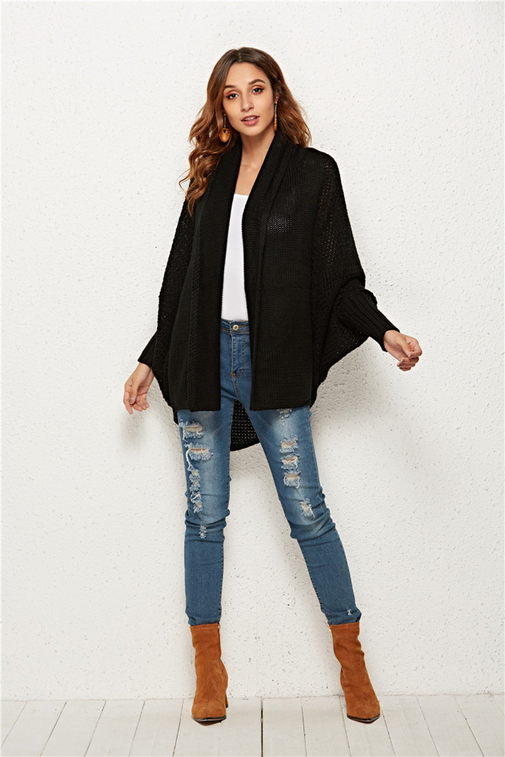 Black acrylic knit cocoon cardigan with batwing sleeves and waterfall neckline.