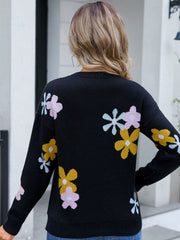 Black crewneck pullover sweater with floral intarsia knit pattern in pink, yellow, and light blue.