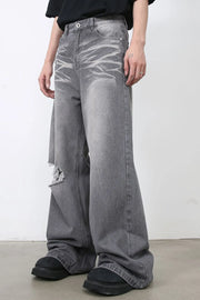 Distressed dark gray wide-leg denim jeans with a ripped knee detail.
