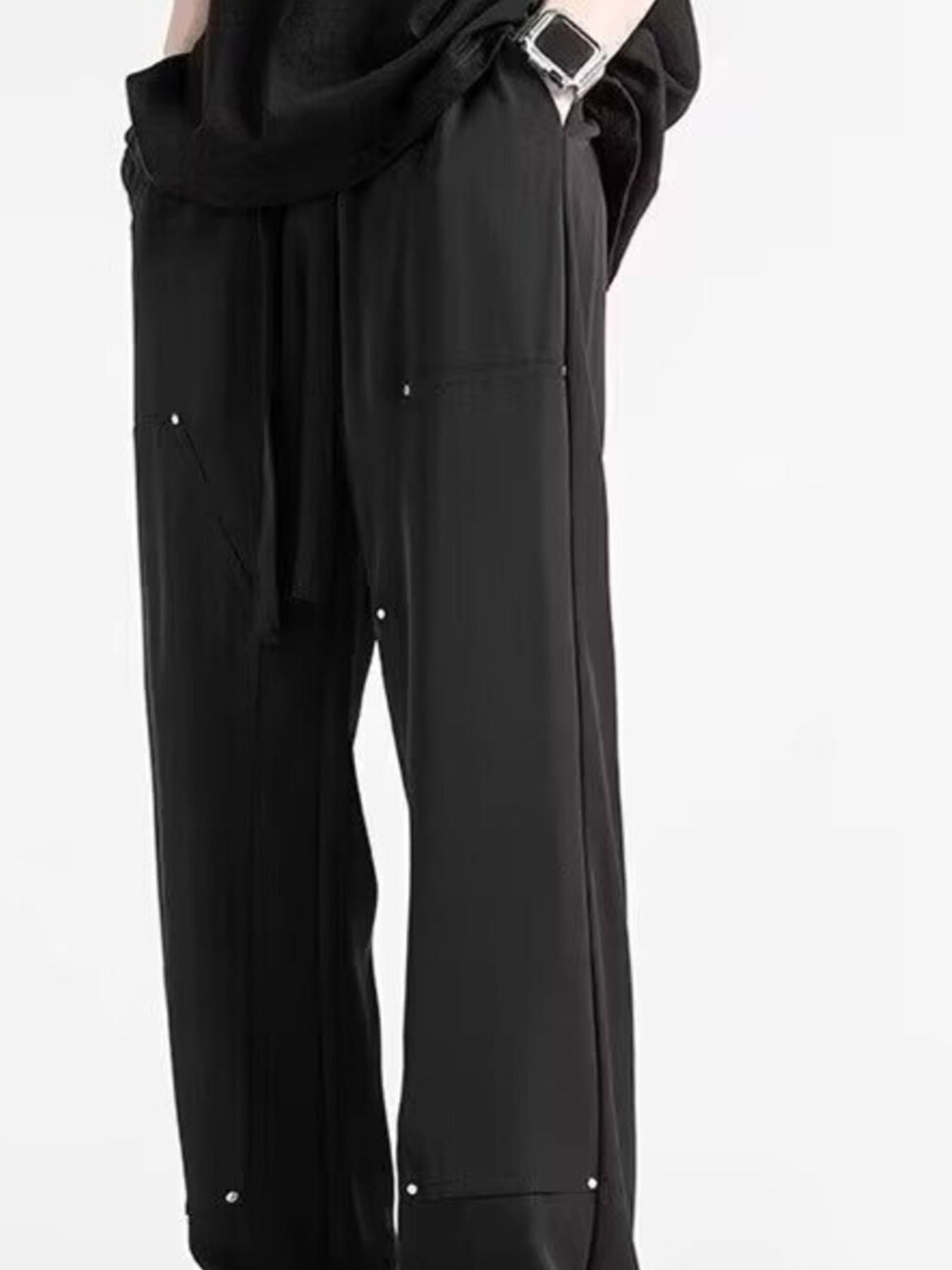 Men's black relaxed drawstring sweatpants with silver stud details.