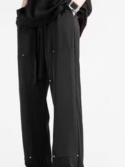 Men's black relaxed drawstring sweatpants with silver stud details.