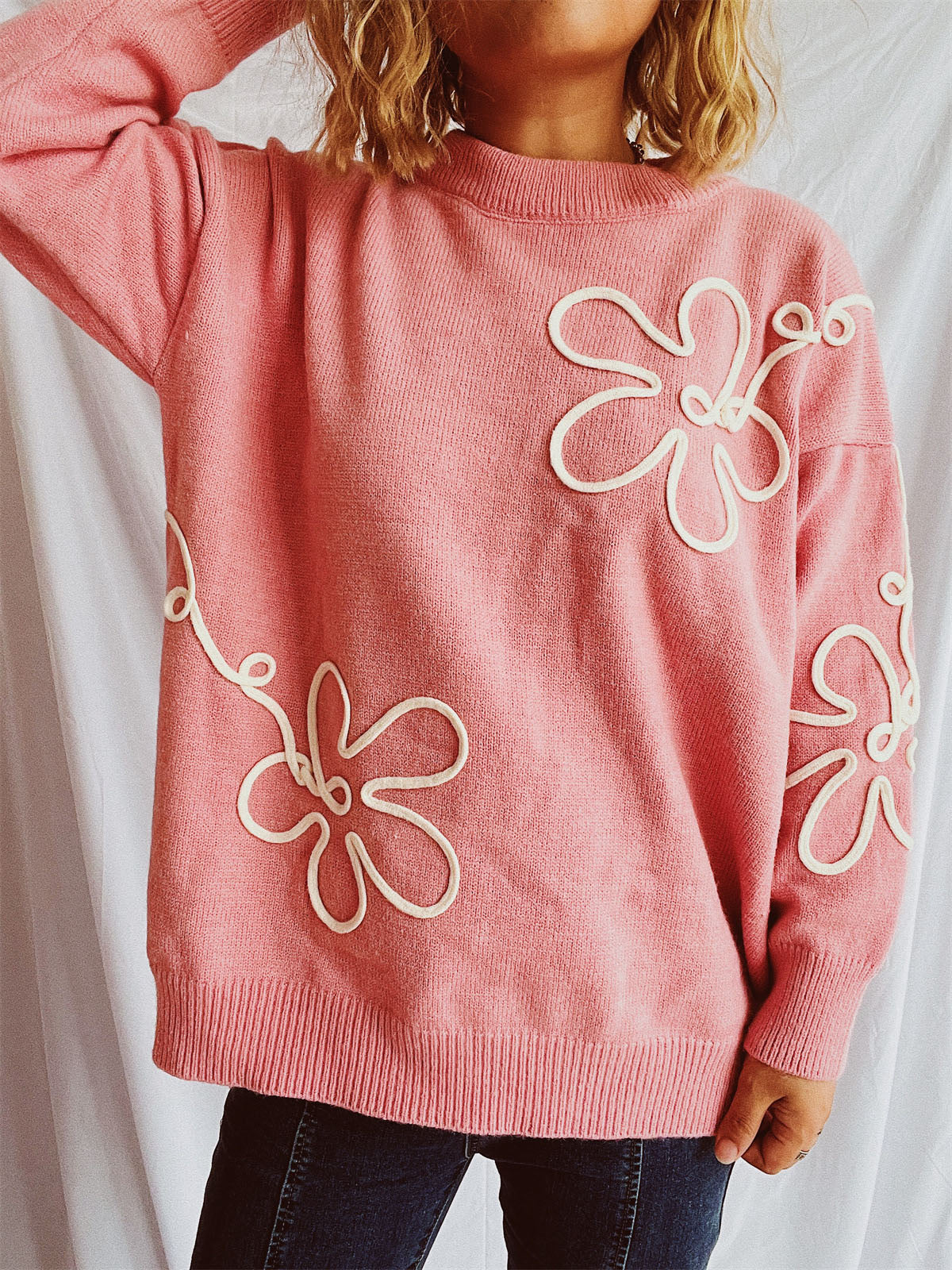 Watermelon pink acrylic knit sweater with white floral outline detail.