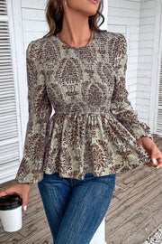 Brown damask print peplum blouse with smocking and long sleeves.