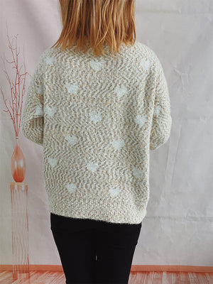 Textured acrylic turtleneck sweater with a subtle heart pattern in cream and beige.