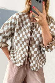 Checkered tie-front knit cardigan with ruffle sleeves in taupe and white.